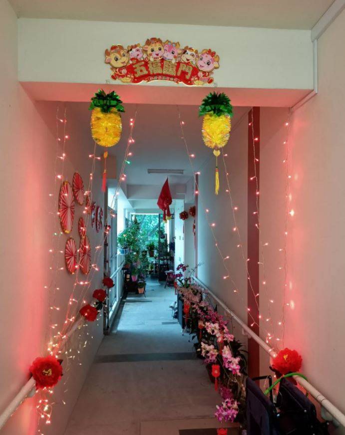 一名穆斯林也一起过华人春节,替组屋老人摆上春节装饰