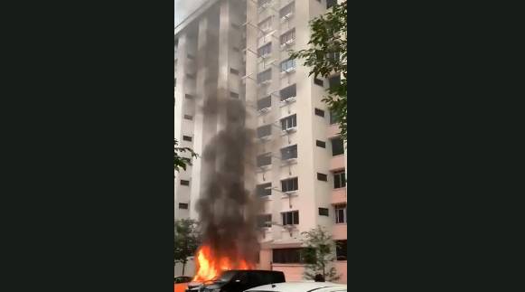 新加坡组屋区停车场的货车突然起火，路人争相拍照