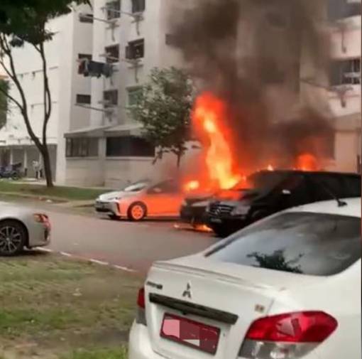 新加坡组屋区停车场的货车突然起火，路人争相拍照