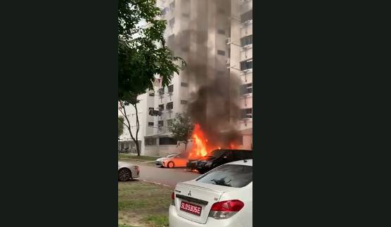 新加坡组屋区停车场的货车突然起火，路人争相拍照